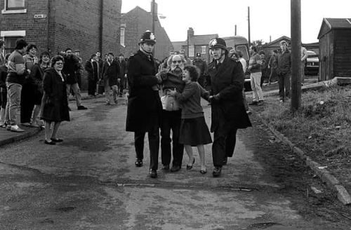 Le premier mineur à reprendre le travail, escorté par la police, est observé par les habitants. Keith Pattison, août 1984 à Easington. 