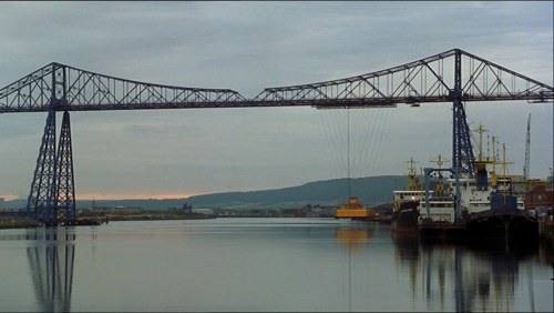 Le pont roulant, structure industrielle imposante qui surplombe le bras d'eau traversé par Billy et madame Wilkinson est lui aussi recouvert d'une peinture vive bleue et jaune.